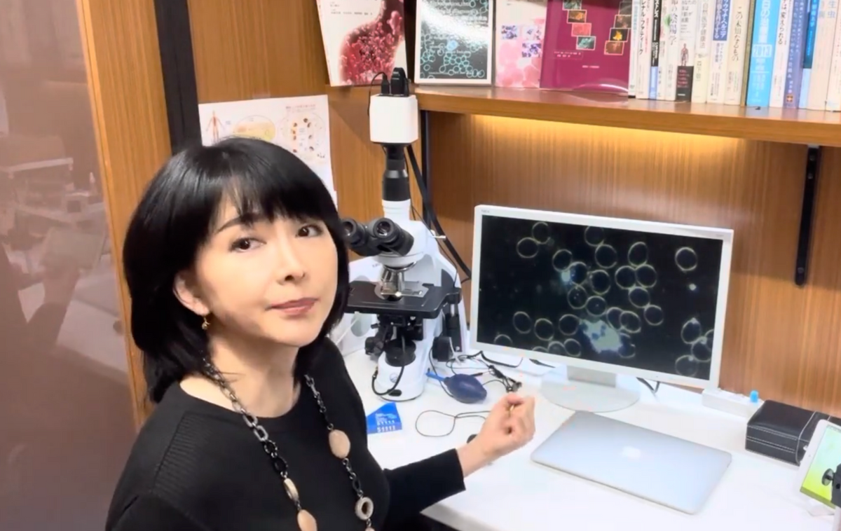 赤須知美が顕微鏡と血液ライブ画像モニターの前でカウンセリングする様子