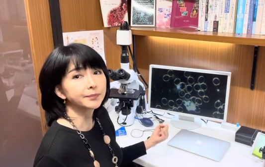赤須知美が顕微鏡と血液ライブ画像モニターの前でカウンセリングする様子